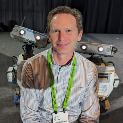 Headshot of Evan Ackerman (with robots)