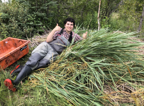 Caleb Alexander on a pile of vegetation