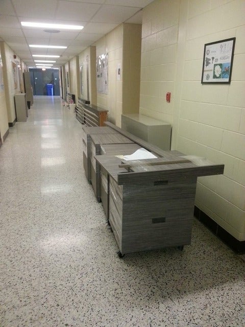 cabinets in hallway, ready to be installed in the new office