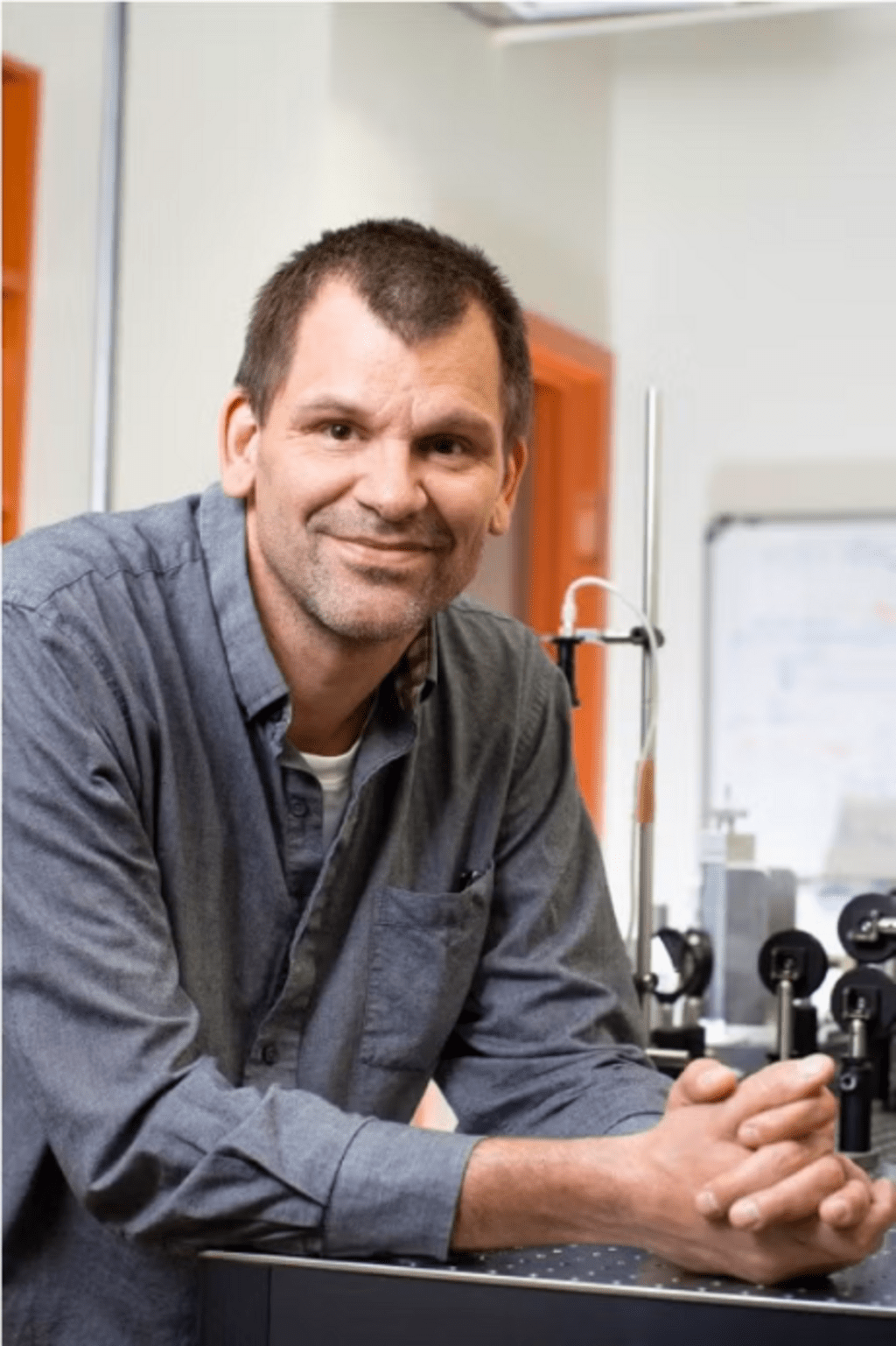 man leaning arms against lab table