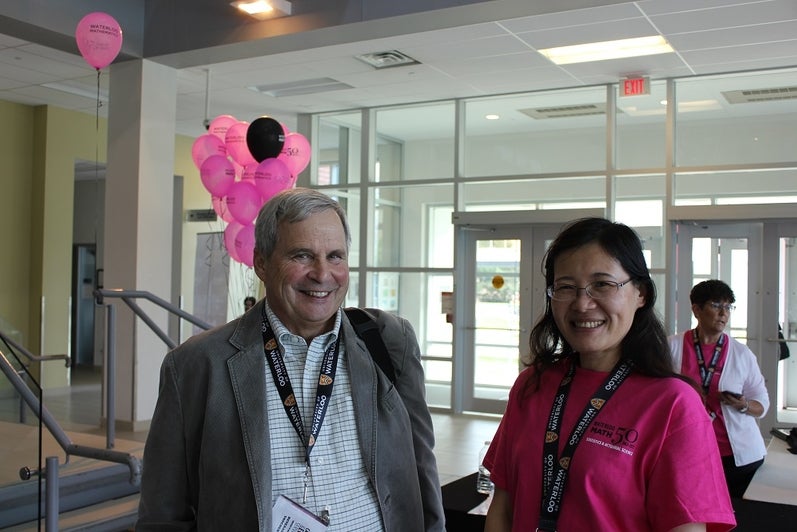 two people smiling with pink balloons in the background