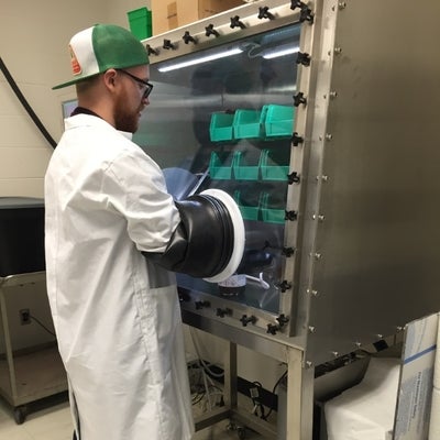 A graduate student using the glovebox in the lab