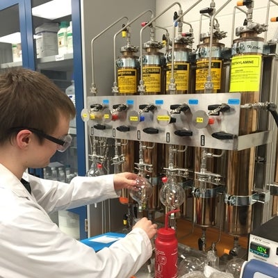 A graduate student using the solvent system in the lab