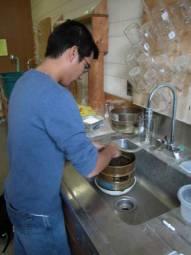 A graduate student washing peat and mineral samples.