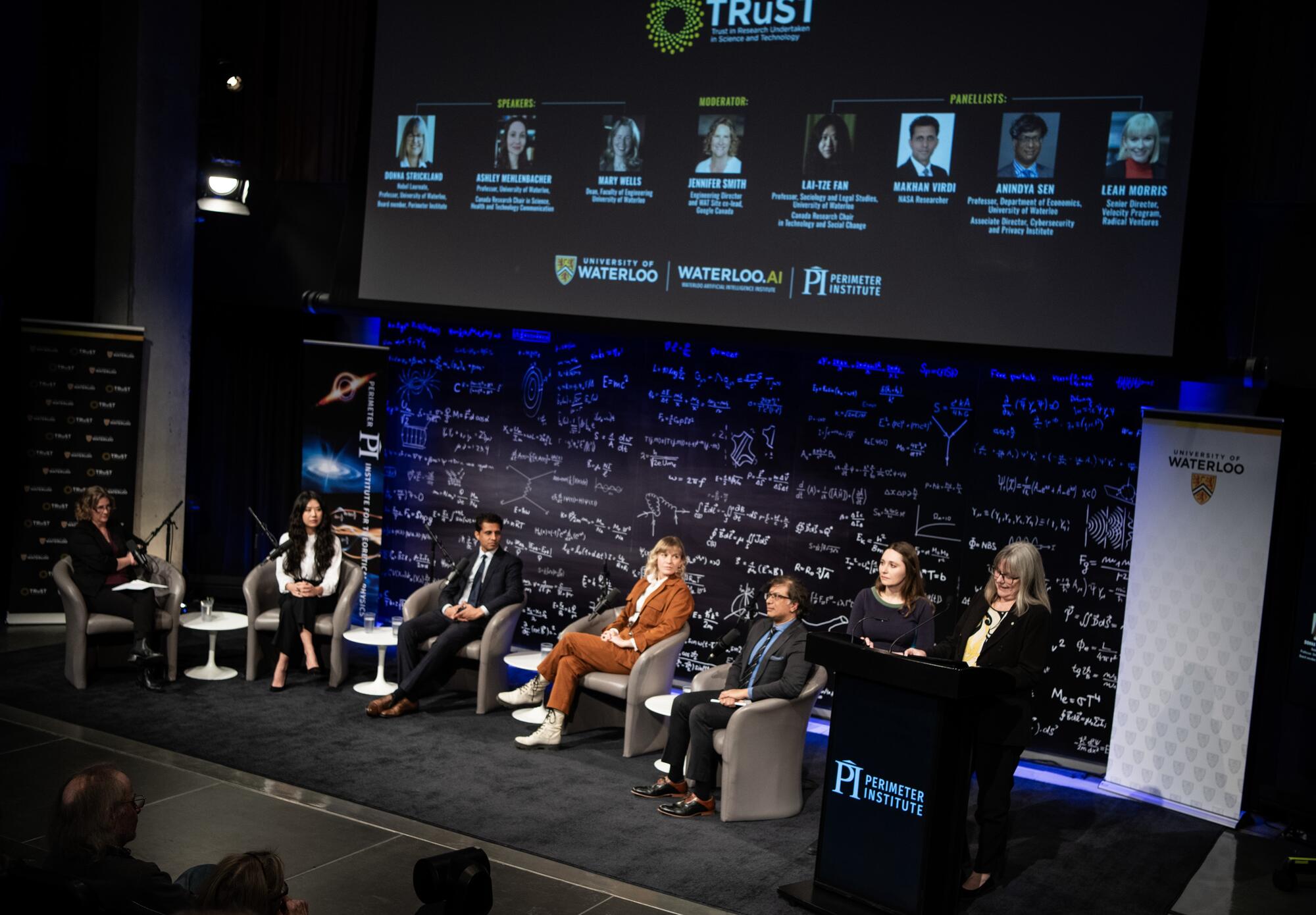 Panel members and TRuST Co-Directors Ashley Rose Mehlenbacher and Donna Strickland standing on stage at the Perimeter Institute for Theoretical Physics. Gabriela Secara/Perimeter Institute.