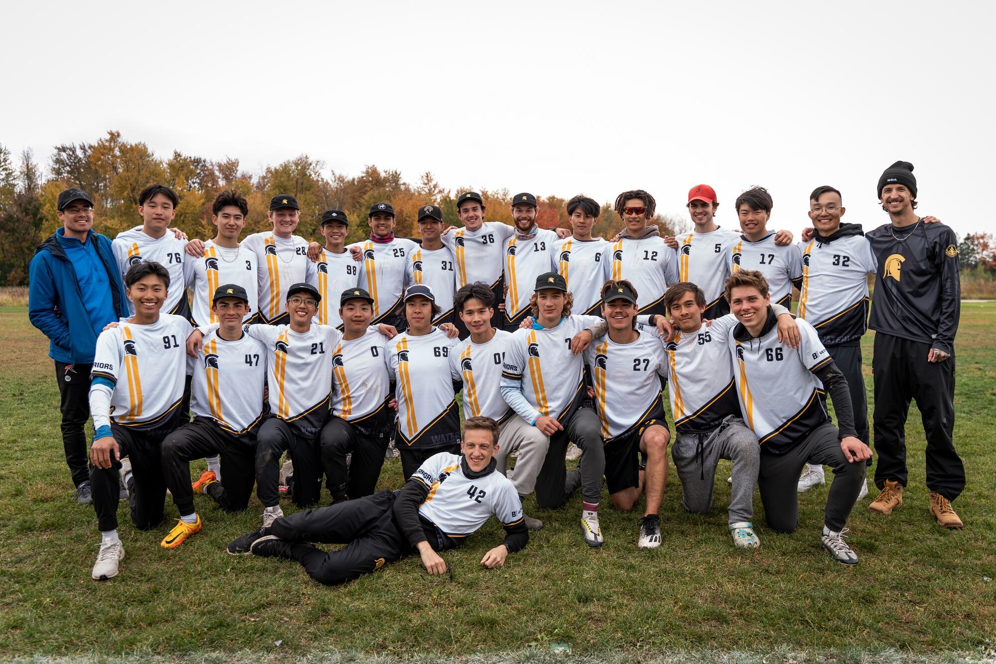 A group of 28 men in two rows, wearing white jerseys.
