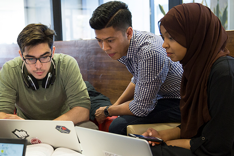 Three students looking at laptop