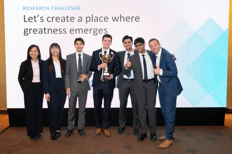 Team of students with faculty and industry mentors celebrating their win with a trophy