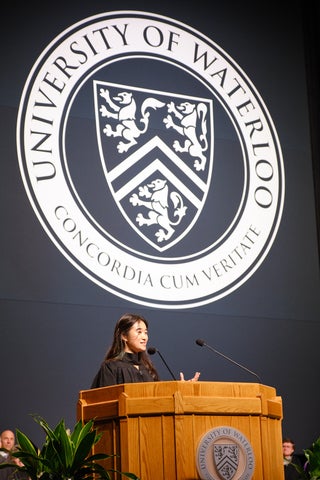 Natasha Chen addresses the crowd from the podium at convocation