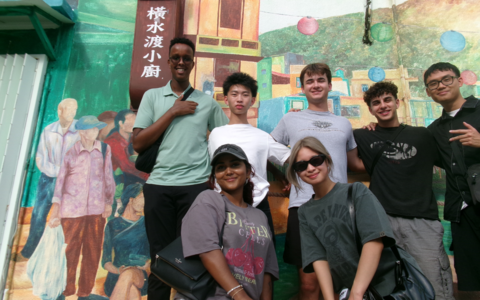 SAF International study trip students in front of a mural in Hong Kong.