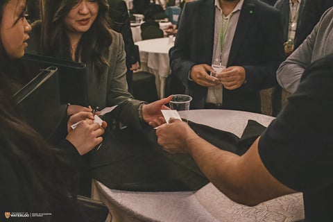 Person handing over business card at Opportunities in Accounting and Finance