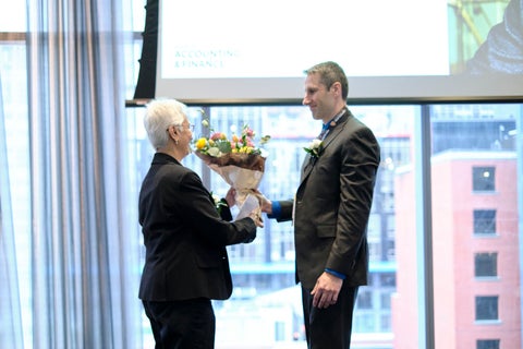 Tim Bauer hands flowers to Ranjini Jha