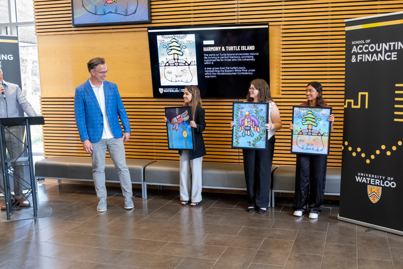 Blake Phillips being presented with three prints of the mural