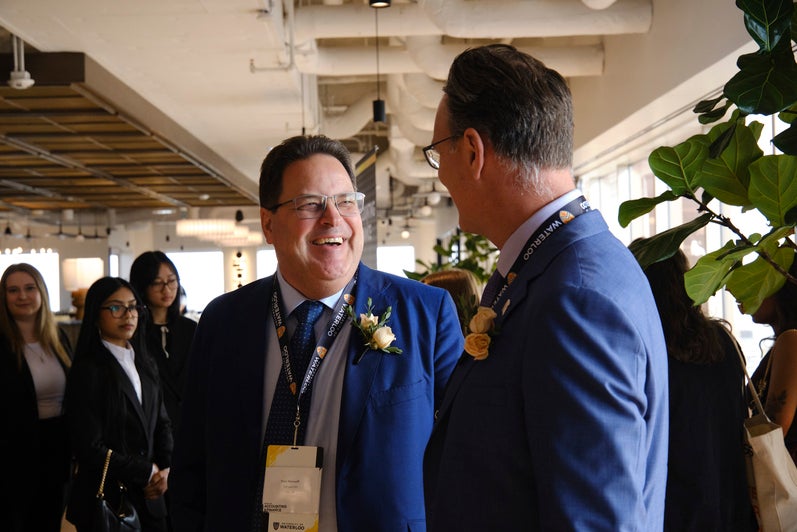 Troy Maxwell smiles at SAF Director Blake Phillips in a crowd of gala guests