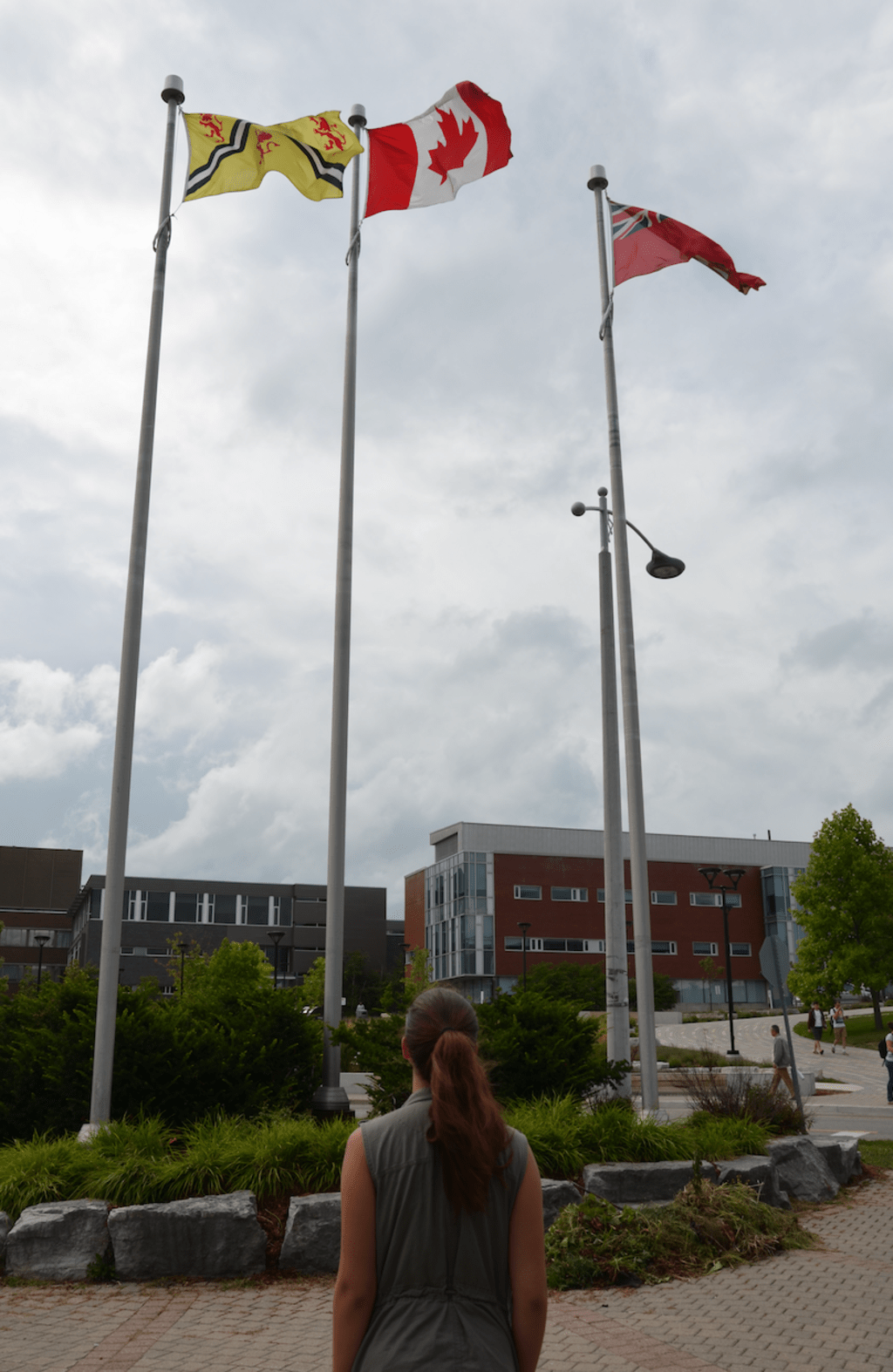 kyrie looking up at flags on Waterloo campus