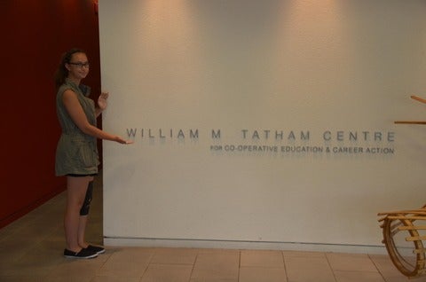 Kyrie at Tatham Centre standing beside the Tatham Centre sign