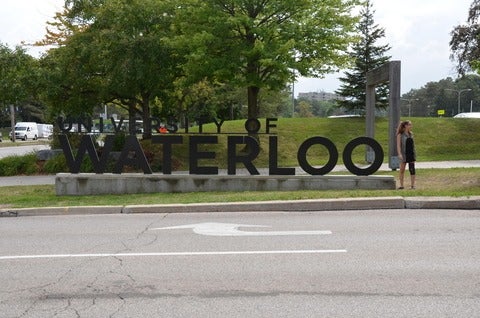 Kyrie with University of Waterloo sign, looking away.