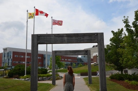 Kyrie standing near the University of Waterloo sign on Seagram Drive
