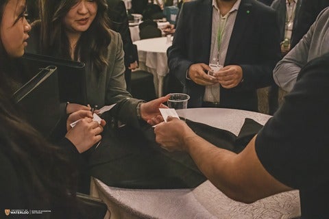 Person handing over business card at Opportunities in Accounting and Finance