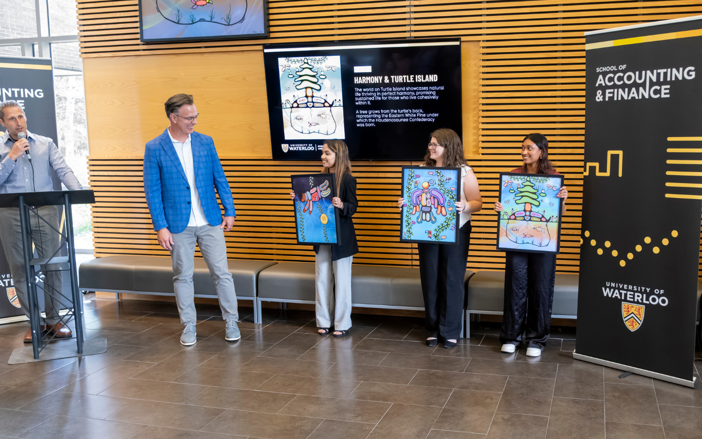 Blake Phillips being presented with three prints of the mural