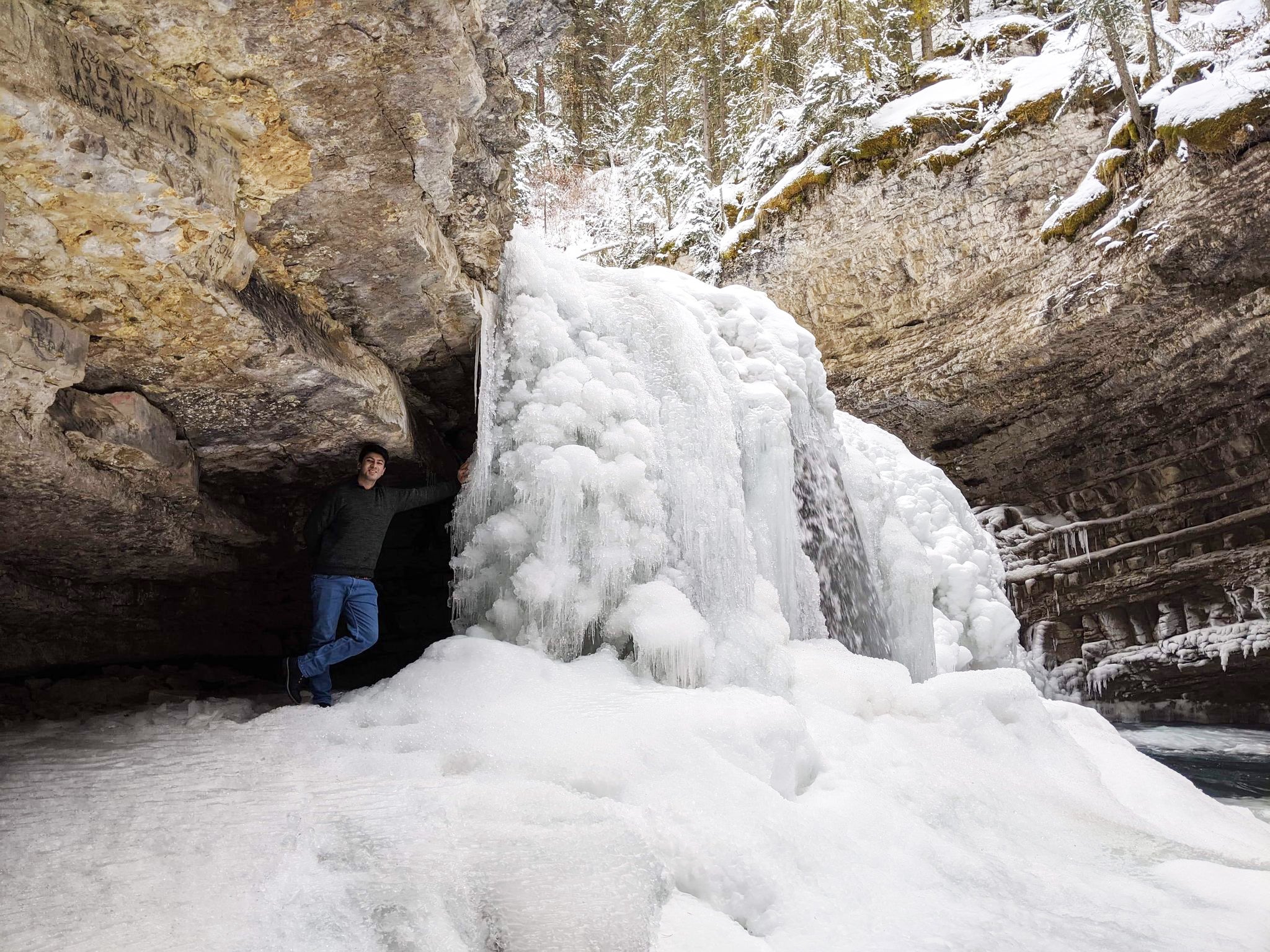 Shan standing beside frozen waterfall