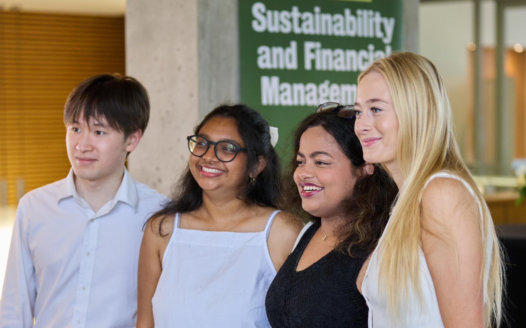 Four SFM graduates pose for a photo together.