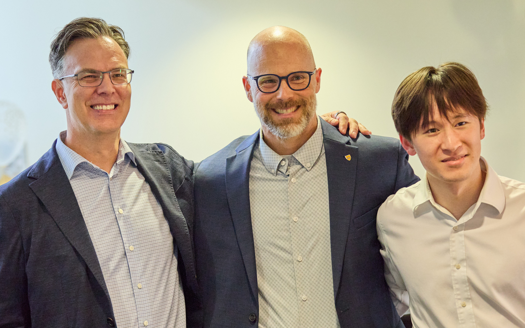 Blake Phillips and Michael wood pose for a photo with an SFM graduate.