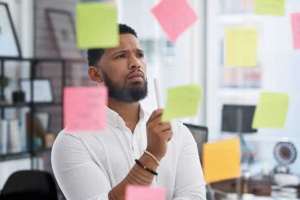 Man looking at sticky notes on mirror