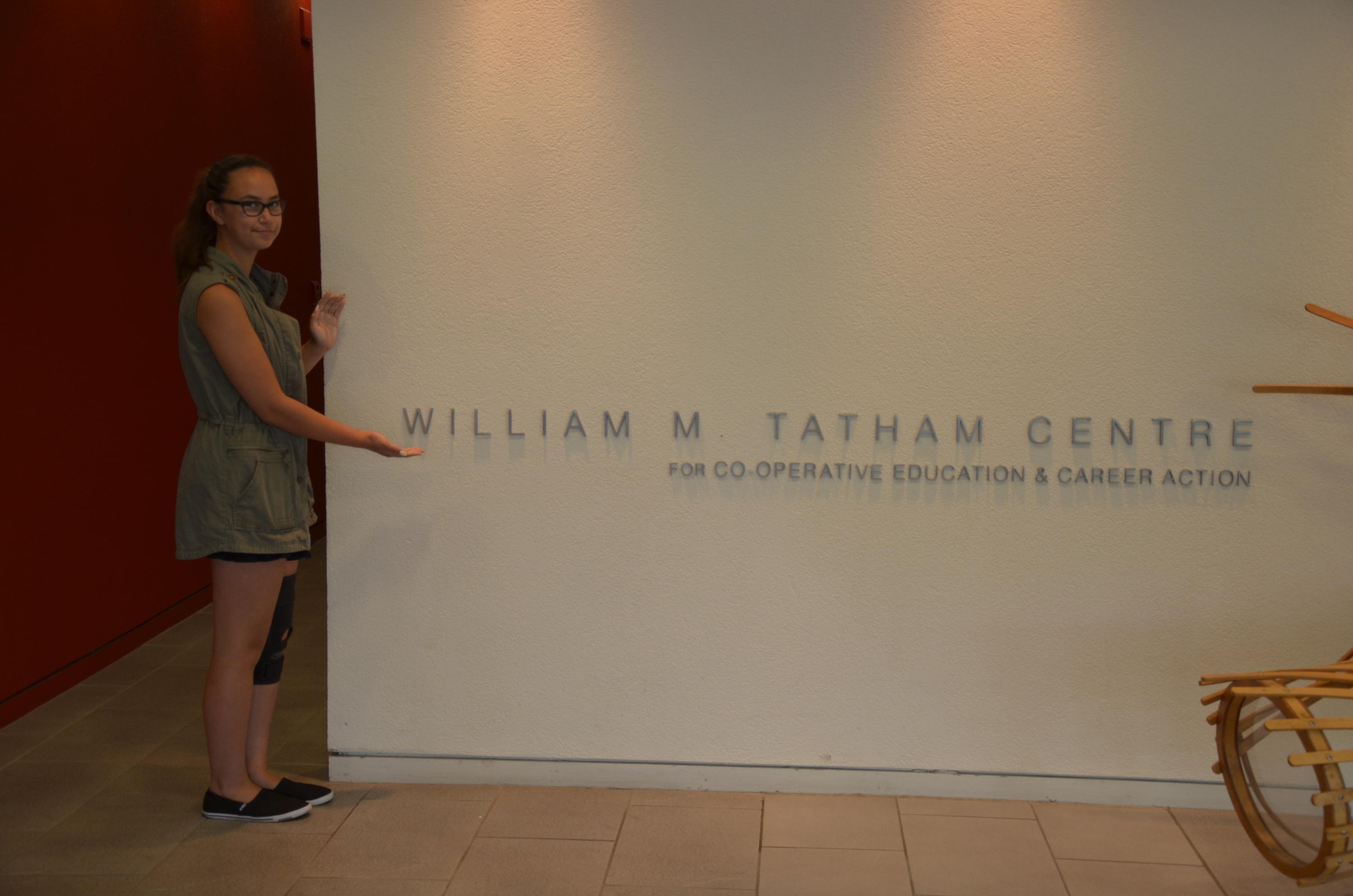 Kyrie at the Tatham Centre standing beside the Tatham Centre sign 