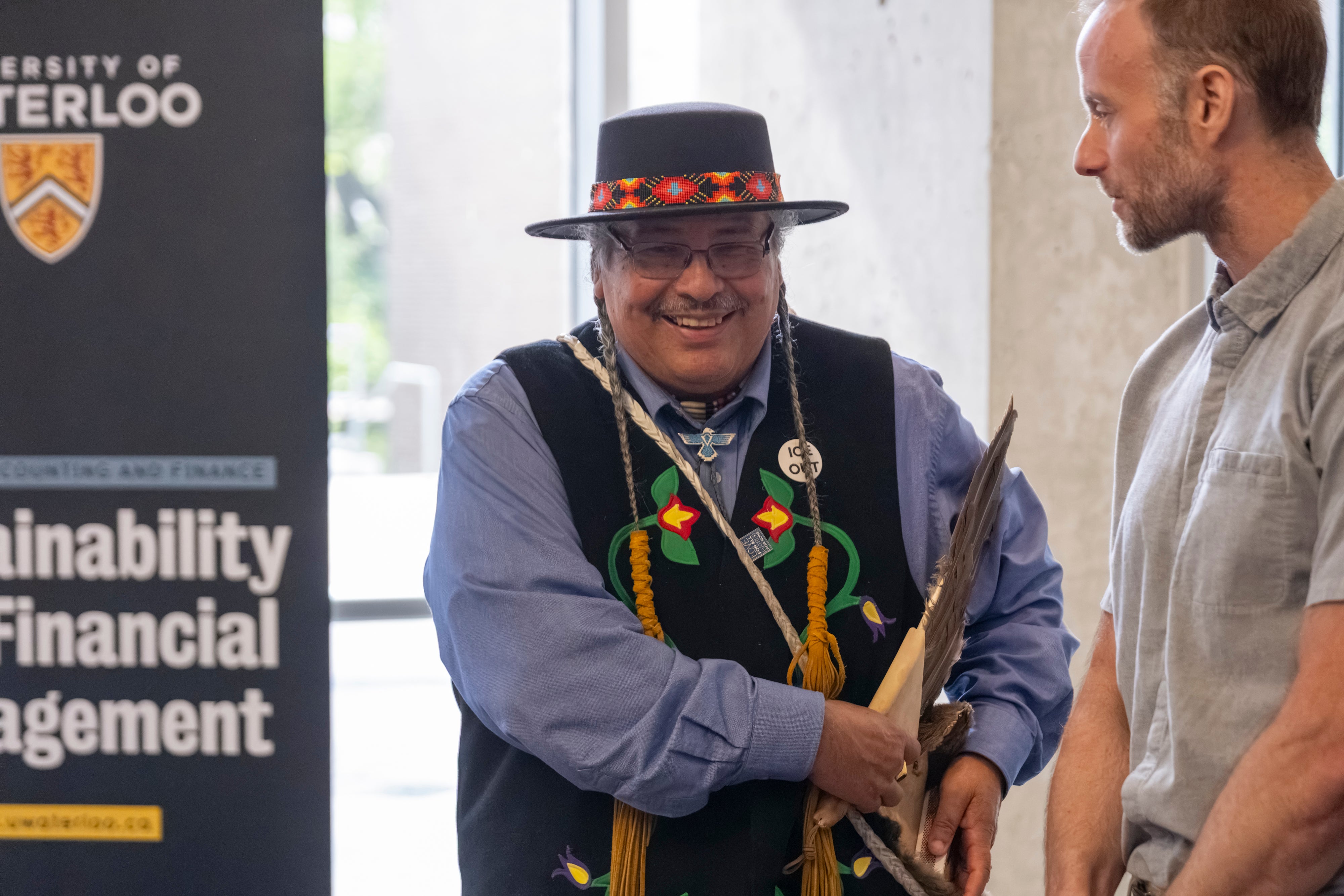 Elder Henry, Waterloo's Indigenous Knowledge Keeper, smiles while chatting with a SAF faculty member