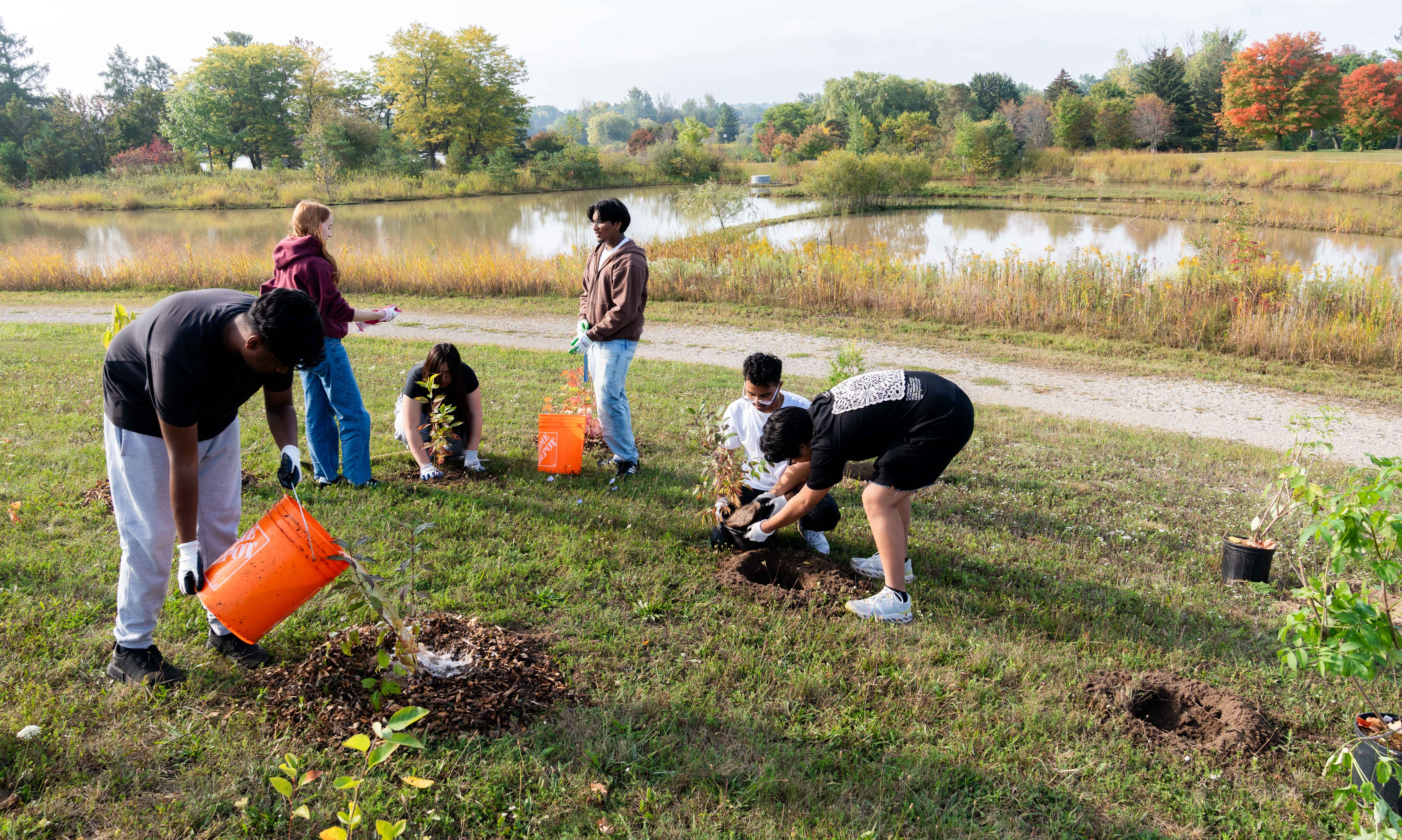 SFM students planting and watering trees at the SFM tree planting event