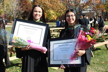 Stephanie and Jessica Nguyen holding their diplomas and flowers