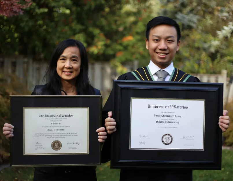 Winnie and Aaron holding their diplomas