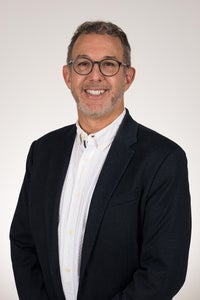 portrait of man in black suit smiling at camera