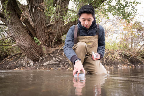 A student is taking water sample.