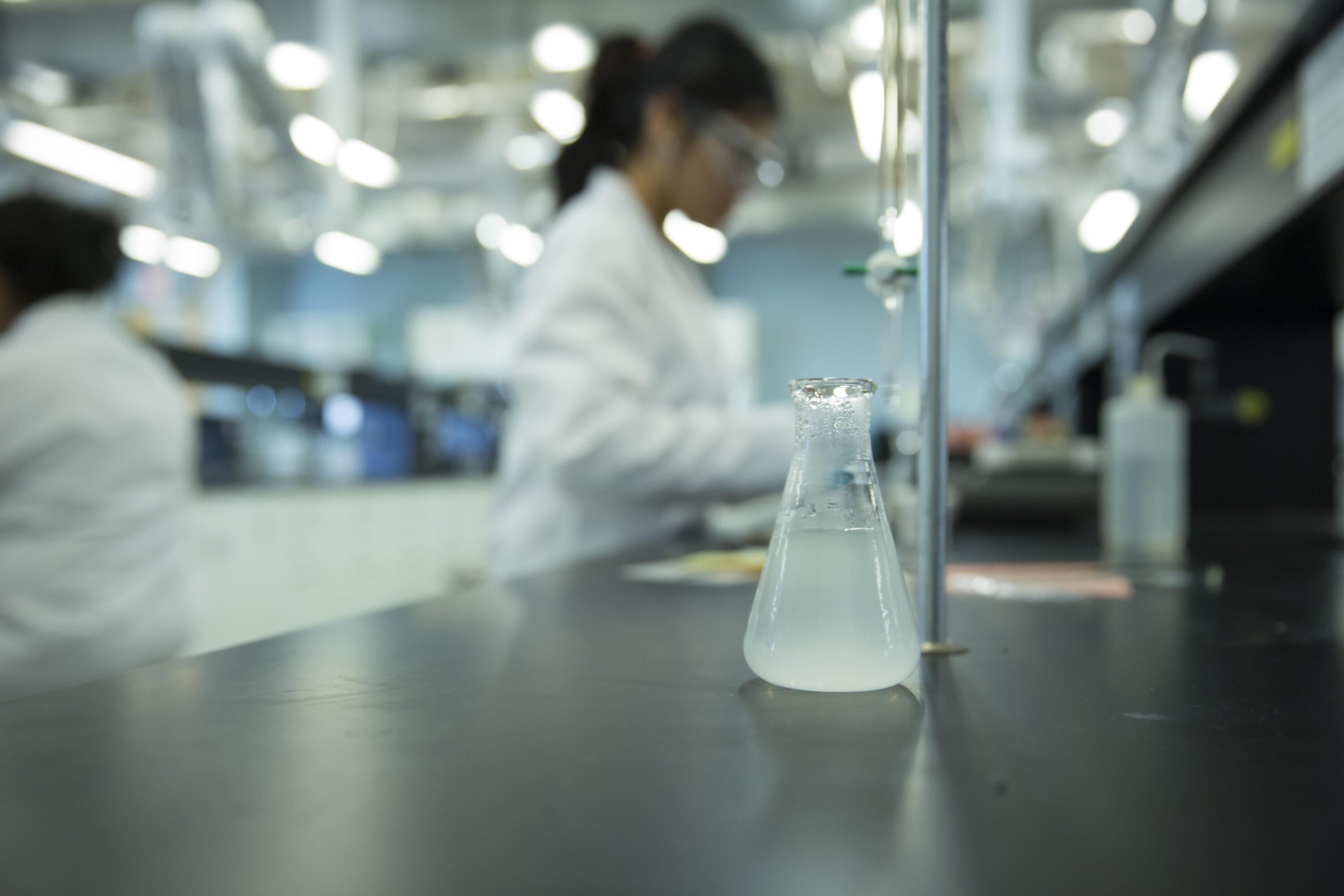 Flask with a student standing at background