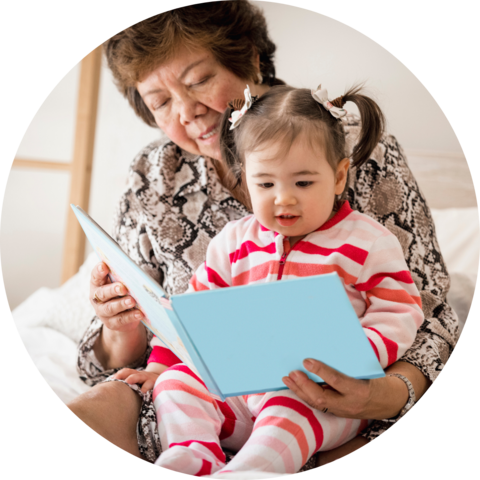 A grandmother reading to her granddaughter