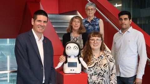 Ben Thompson, and 4 collaborators standing beside a social robot
