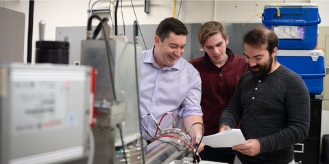 Scott Hopkins and two students in the lab