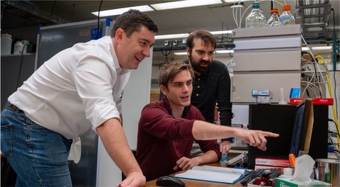 Scott Hopkins and two students in the lab