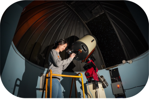 Student looking through a telescope in the Waterloo Observatory