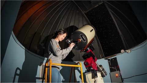 Student looking through a telescope in the Waterloo Observatory