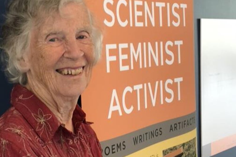 Anne Dagg standing in front of a display case for her exhibit.