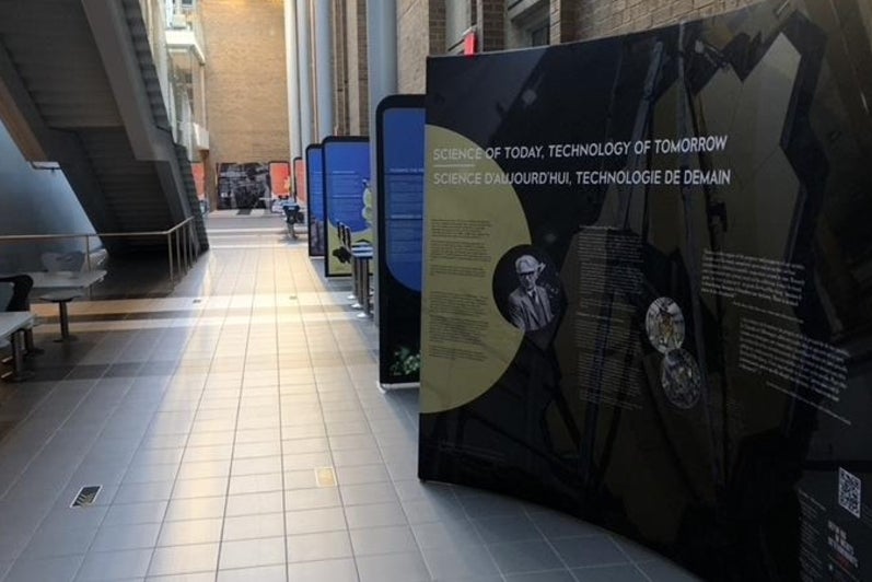 Information kiosks on the Herzberg exhibit set up in a hallway.