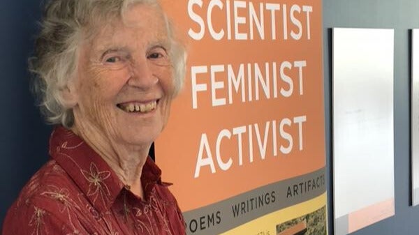 Anne Dagg standing in front of a display case for her exhibit.