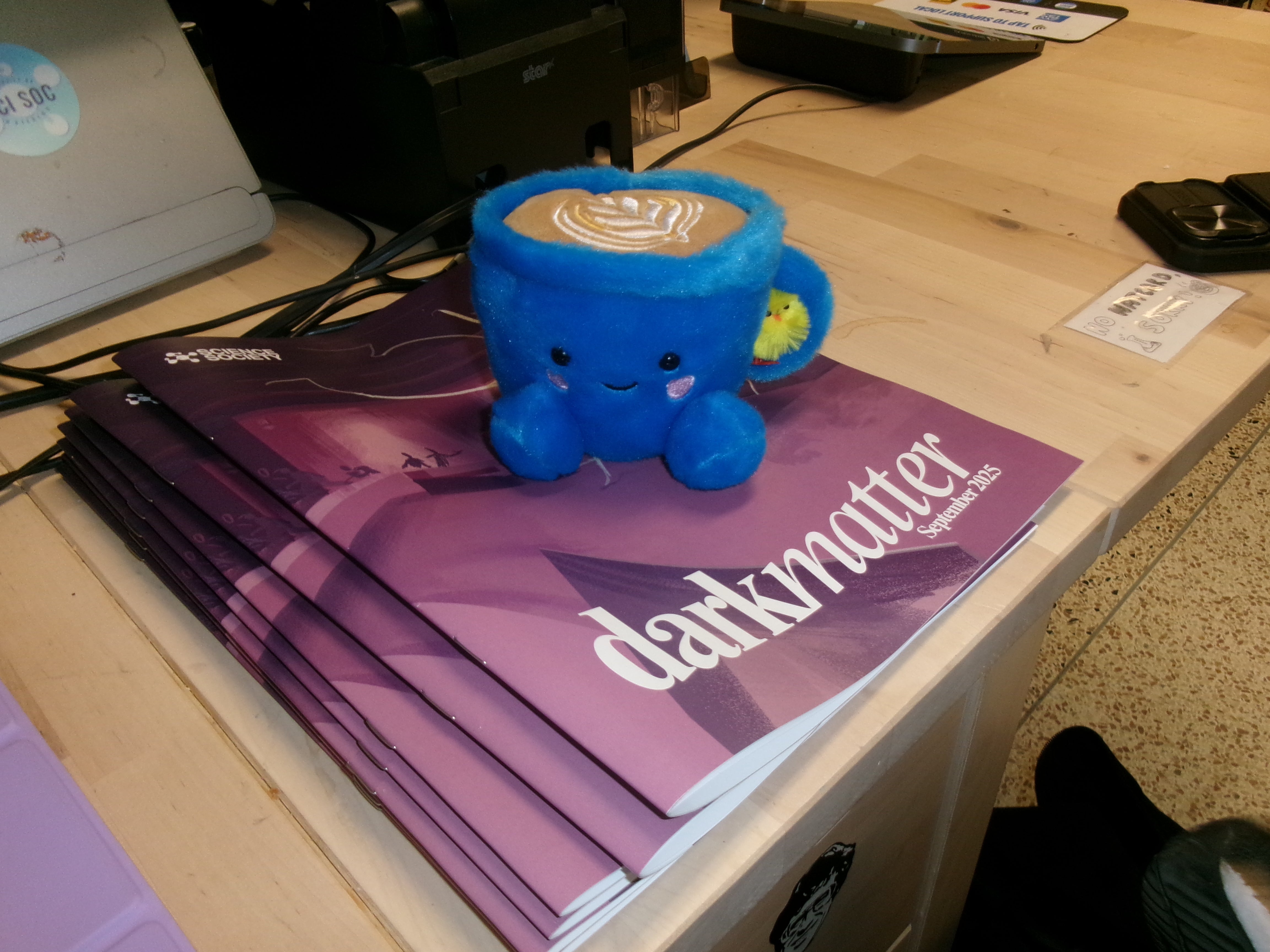 Coffee cup plushie on top of magazine