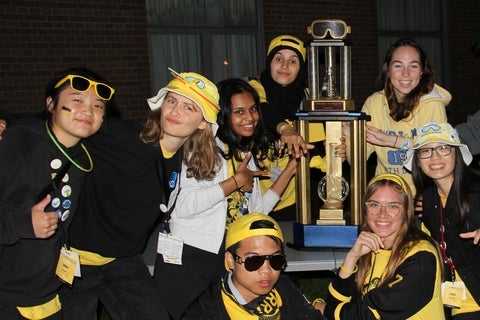 Winning yellow science orientation team with trophy