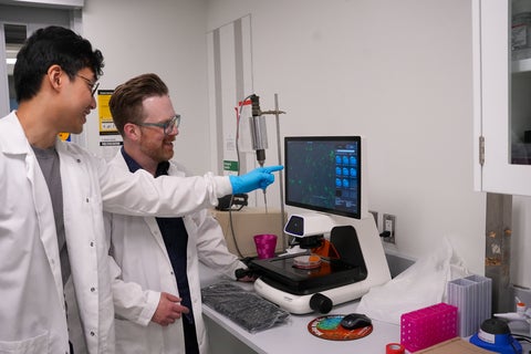 scientist and student looking at computer