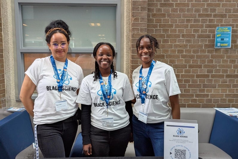 3 Black Science members setting up an information table