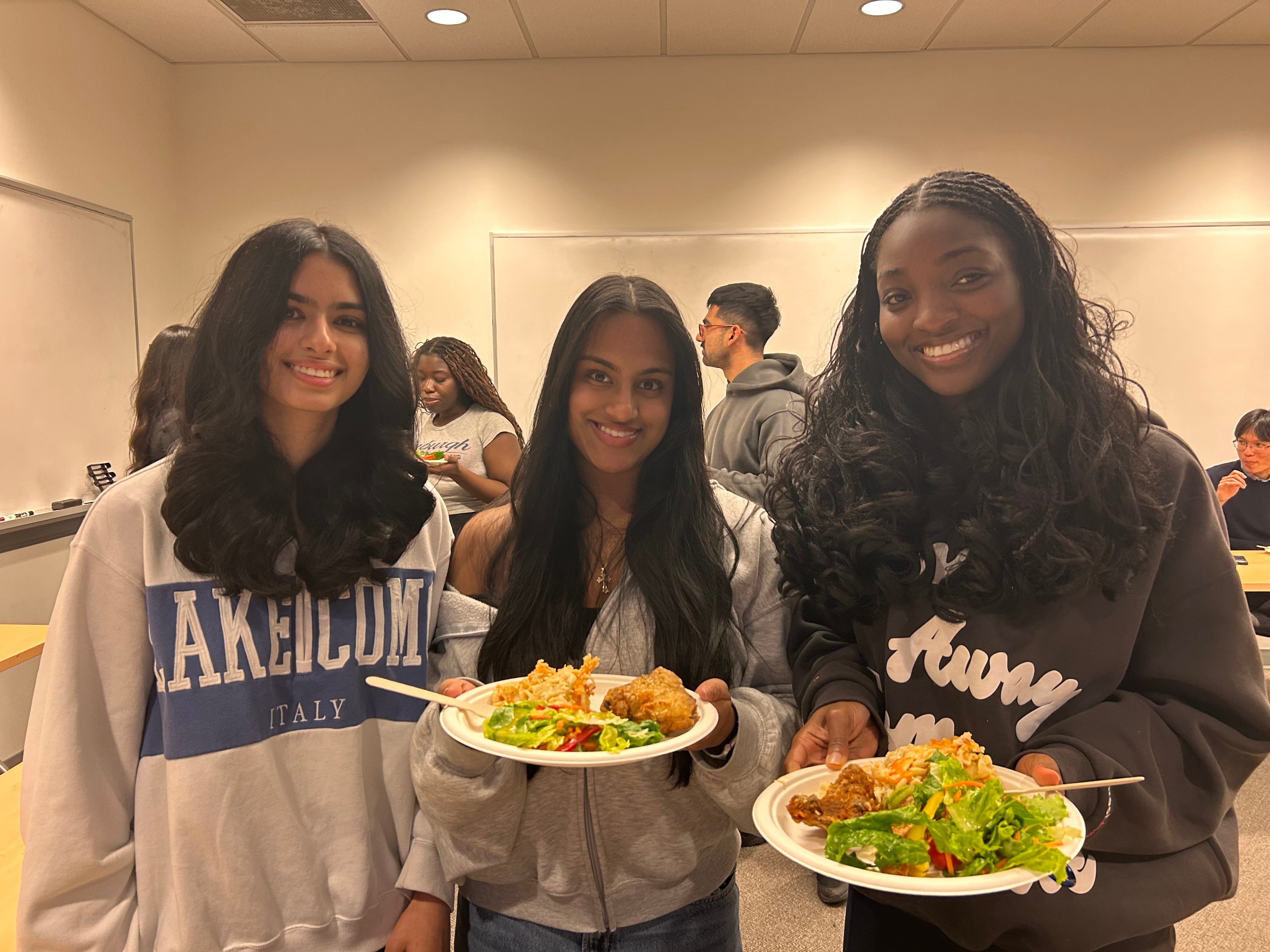 3 students posing with plates of food